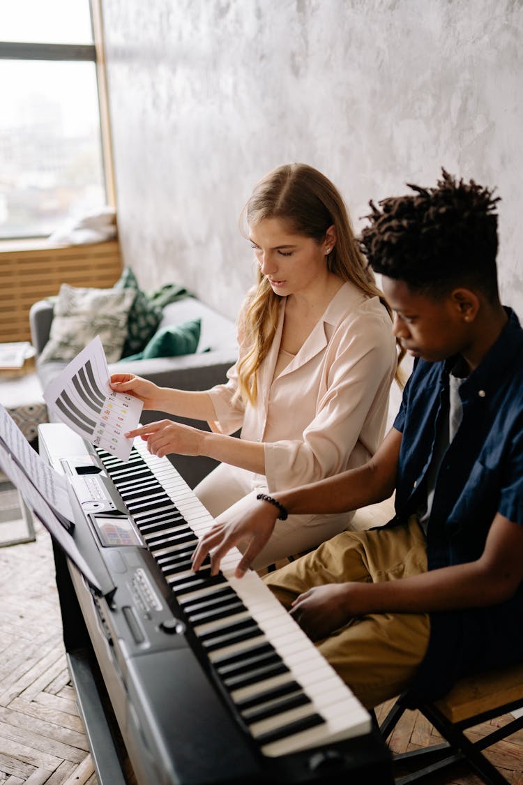 Woman Teaching A Boy How To Play Piano