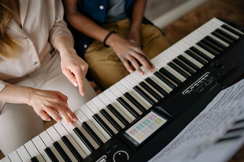 Hands sharing a piano keyboard