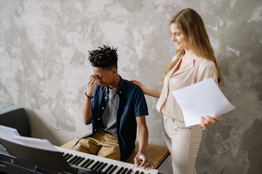 A boy appears frustrated during a piano lesson with a supportive teacher.