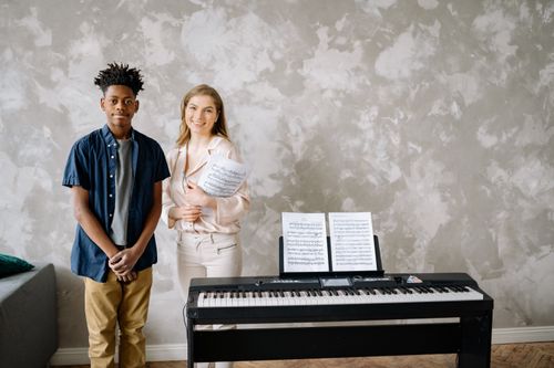 Free Teen and adult with piano and sheet music in a music lesson. Stock Photo