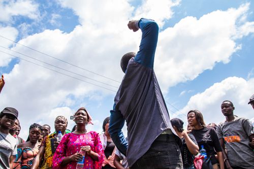 Free A diverse group of people engaged in an outdoor protest with raised voices and arms, displaying unity and motivation. Stock Photo