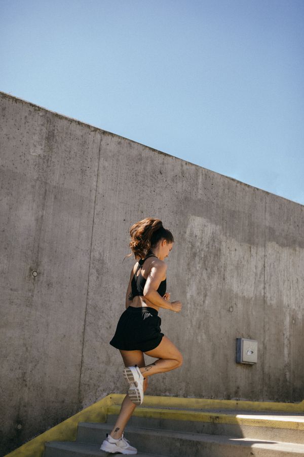 Woman sprinting up concrete stairs