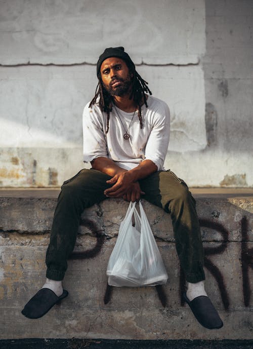 A Man in Beanie Hat While Holding a Plastic Bag