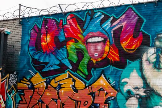 Colorful street art mural featuring vivid graffiti and expressive designs on a brick wall.