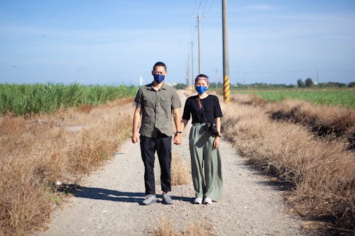 Man and Woman Standing on Dirt Road