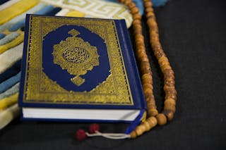 Close-Up Shot of a Book beside Prayer Beads