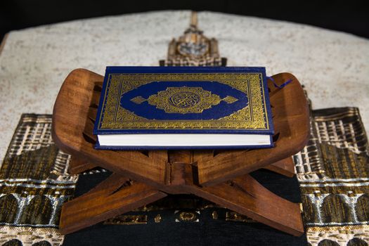 Close-up of the Quran on a wooden stand, symbolizing Islamic spirituality.
