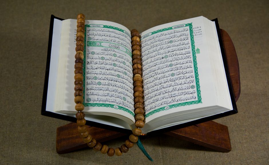 2026'da İslam’ın Şartları Nelerdir? Derinlemesine Bir Analiz 3 An open Quran with prayer beads displayed on a wooden stand, symbolizing Islamic faith and tradition.