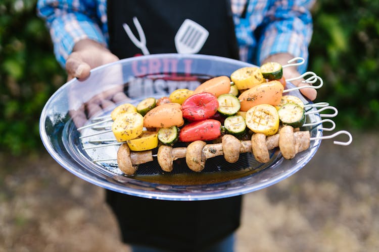 Man Holding Meat And Vegetables On Barbecue 