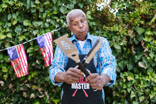 A Man in an Apron Holding Cooking Utensils