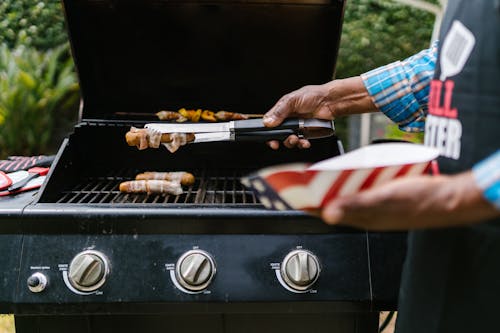 Close-up of a Person Grilling Hotdogs