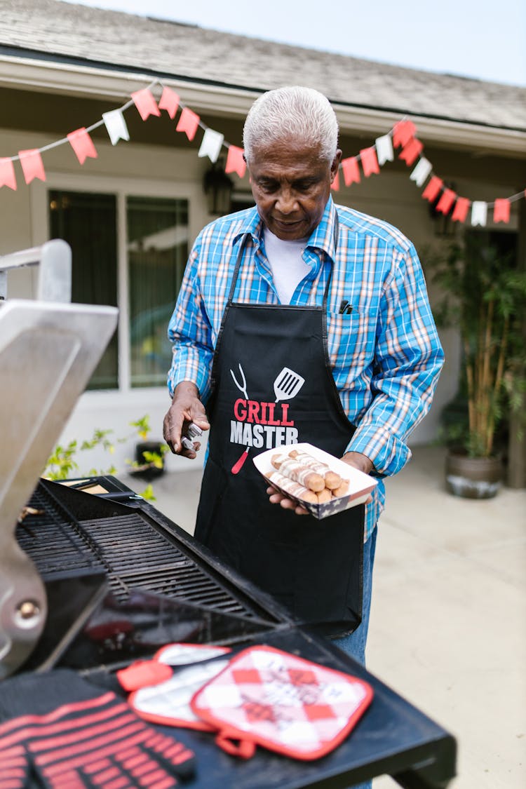 Man In Blue And White Plaid Dress Shirt Holding  Hotdogs