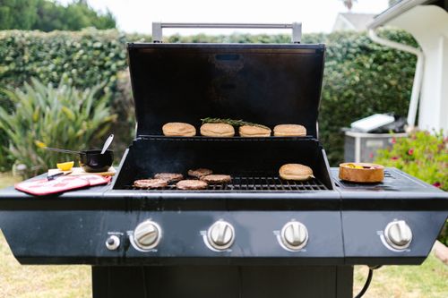 Free Outdoor barbecue grill with burgers and buns, perfect for summer cooking. Stock Photo