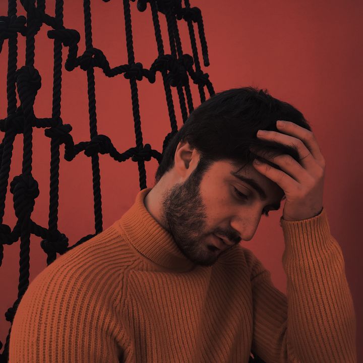Portrait in a rust knit against a terracotta wall, photo by Valeri Mak on Pexels