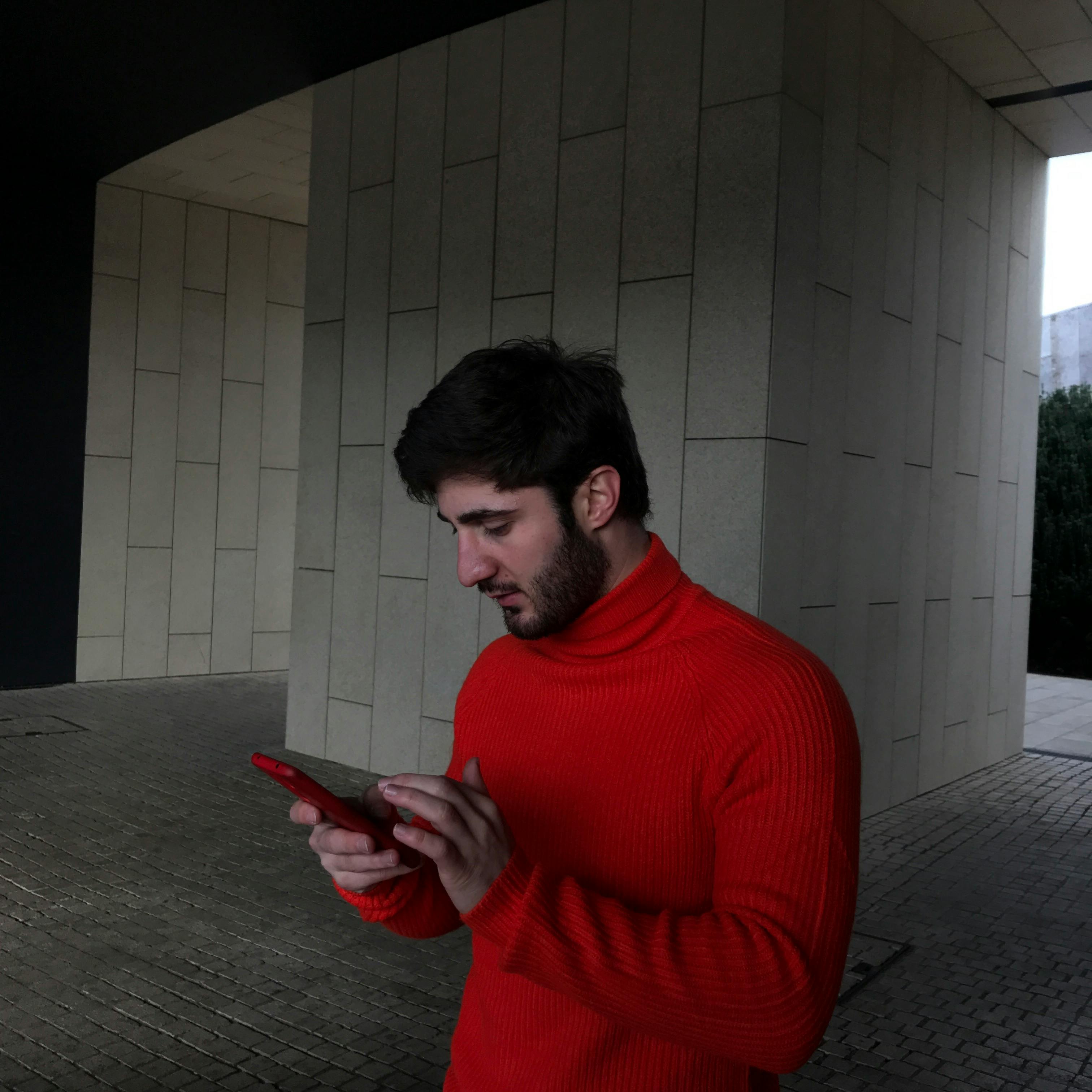 A Man in Red Sweater using Smartphone