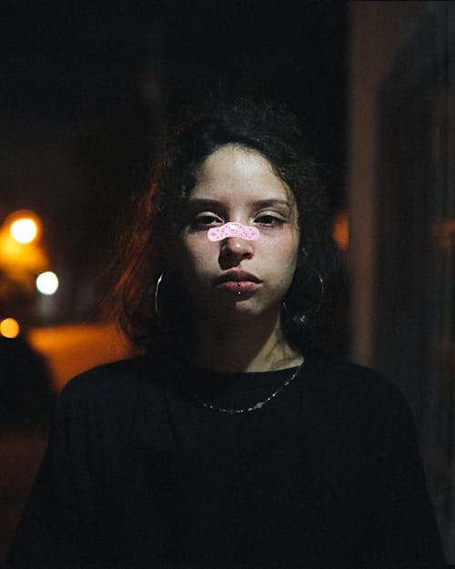 Woman in Black Shirt with a Band Aid on Nose