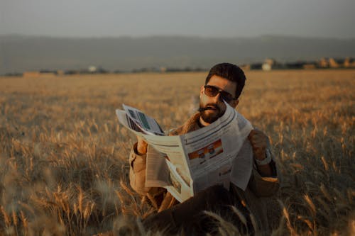 Бесплатное стоковое фото с бородатый мужчина, газета, держать