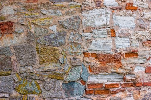 Free Close-up view of a textured wall made of colorful stones and bricks, perfect for backgrounds. Stock Photo