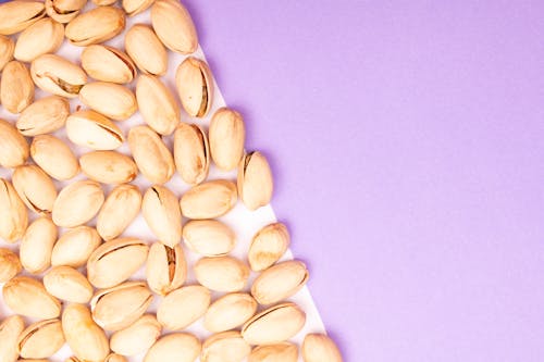 Free Pistachios on White Surface with Purple background Stock Photo
