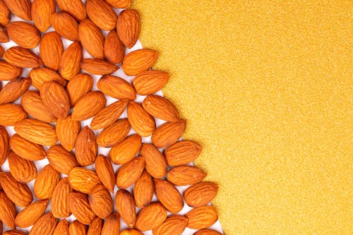 Close-Up Shot of Almond Nuts on an Orange Surface