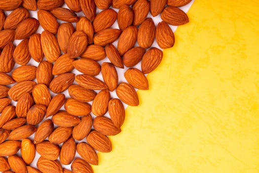 Close-up of organic almonds on a yellow surface with ample copy space.