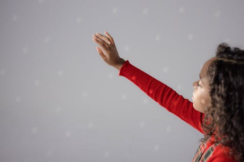 Girl Wearing Red Sweater with Hand Raised