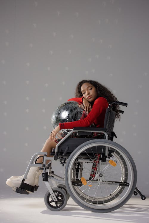 Free Girl Sitting on a Wheelchair with a Disco Ball Stock Photo