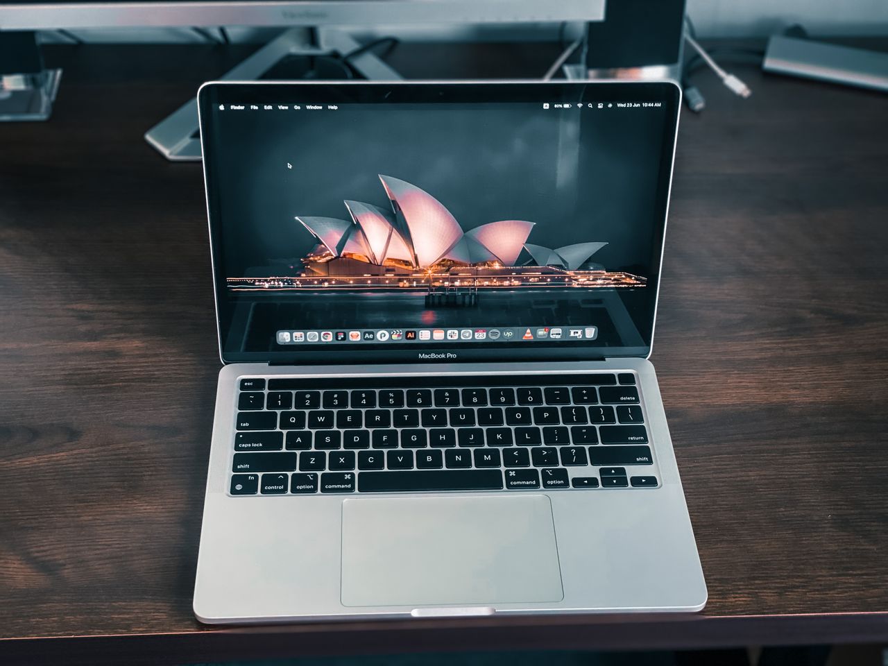 close up of a macbook pro on a desk with sydney opera house wallpaper