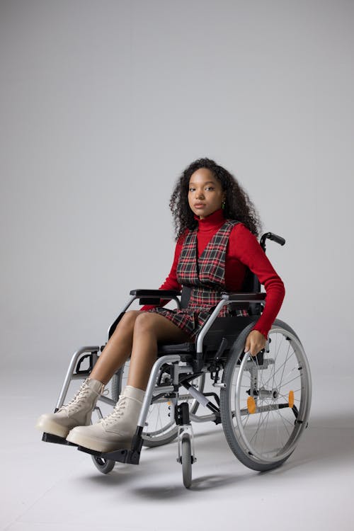 Free A Young Woman in a Stylish Outfit Sitting in a Wheelchair Stock Photo