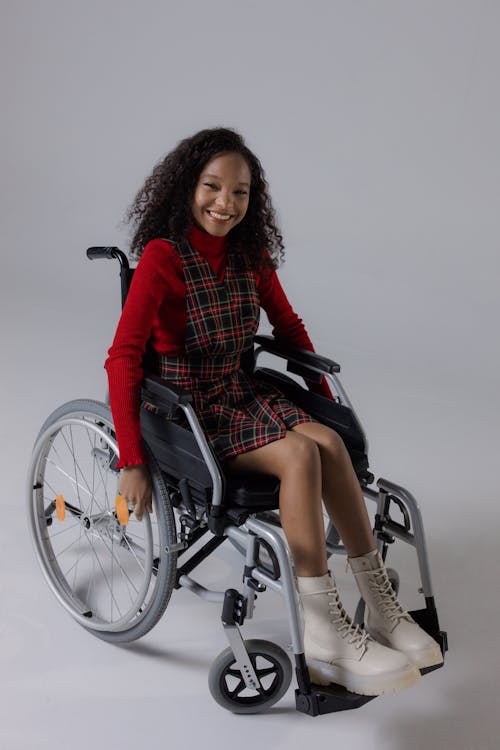 A Girl Riding a Wheelchair · Free Stock Photo