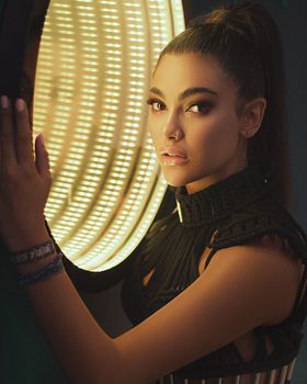 Elegant portrait of a woman with a luminous round light creating a dramatic studio atmosphere.