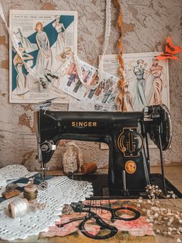 A classic sewing machine surrounded by fashion design sketches and sewing essentials.