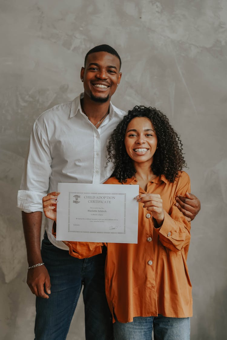 A Happy Couple Holding A Document