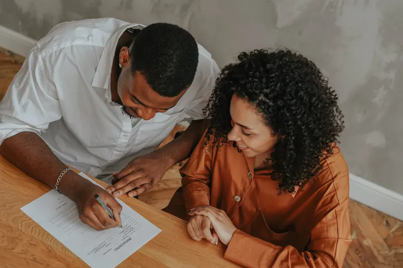 Couple signing home loan papers — illustrating conventional loans explained for first-time buyers
