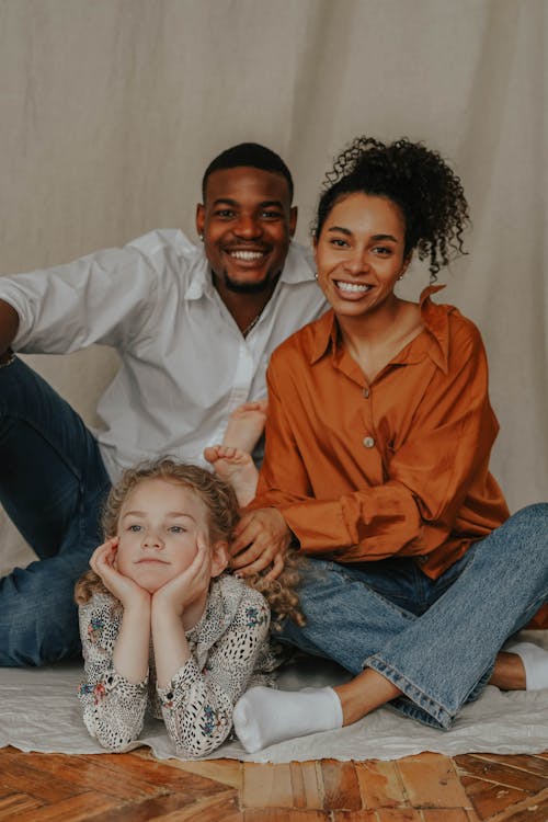 Free A Happy Couple Sitting on the Floor  with their Daughter Stock Photo