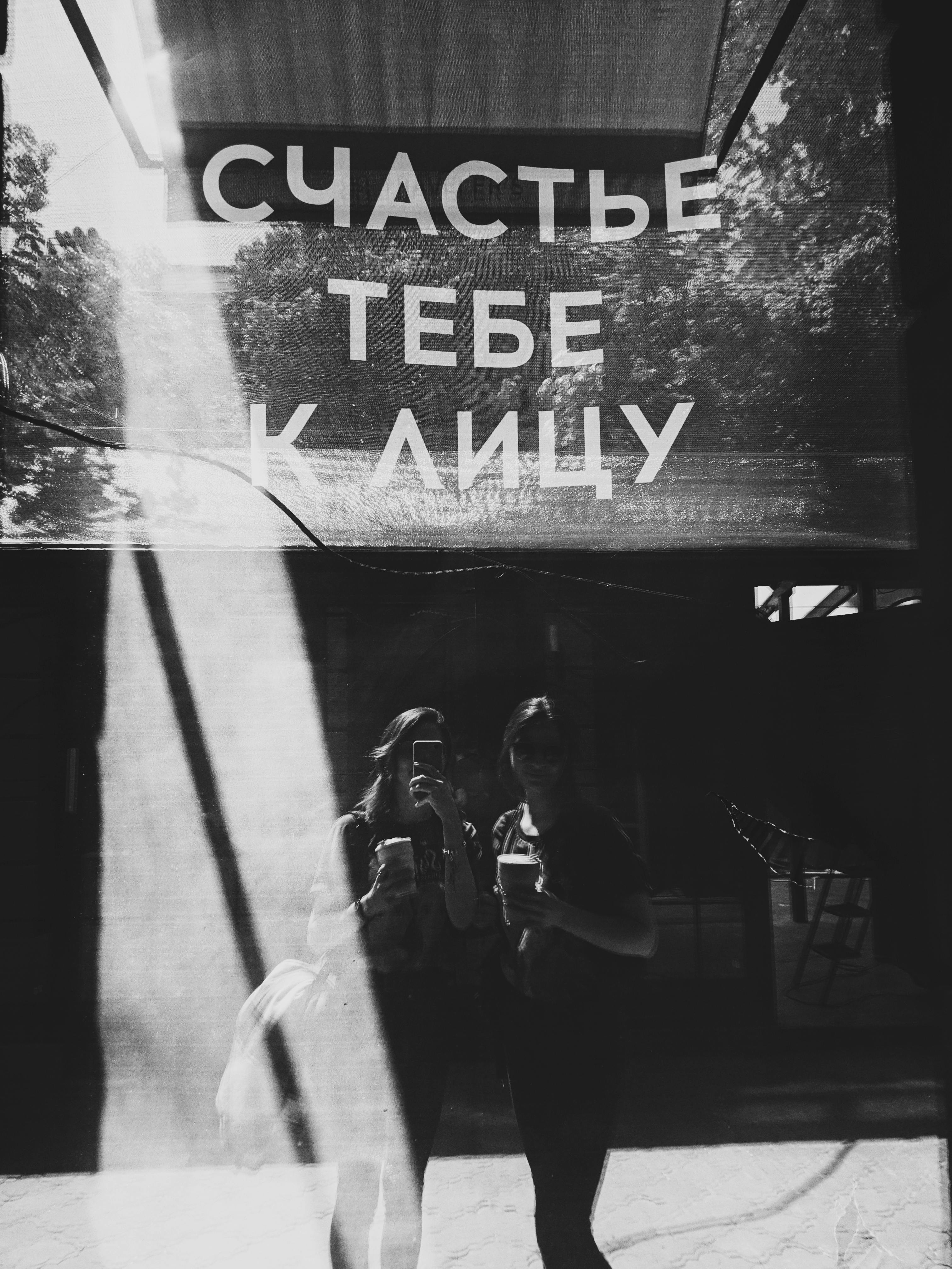 Black and white image of two women taking a reflection selfie in Odesa, Ukraine.