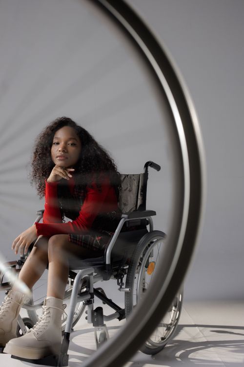 Free Youthful empowerment and diversity shown through a girl in a wheelchair with afro hair. Stock Photo