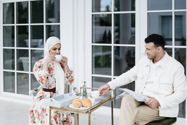 A Man And Woman Having Conversation While Drinking Coffee