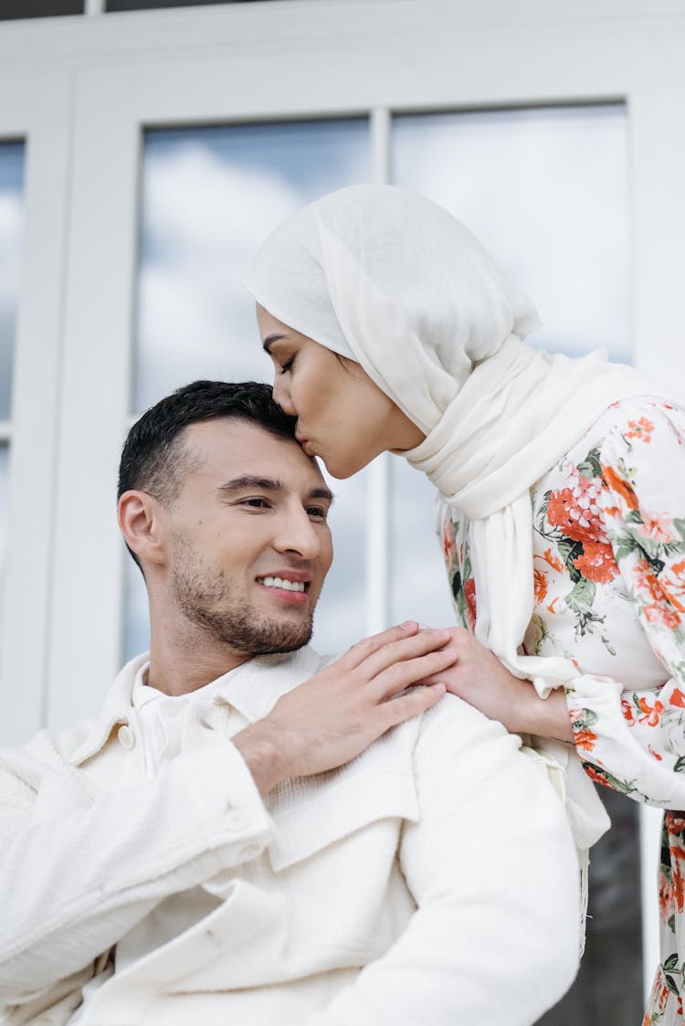 Woman Kissing A Man In Forehead