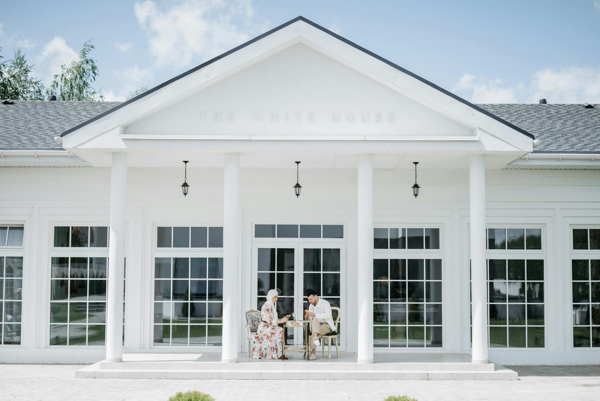 Couple Sitting in Front of a Mansion