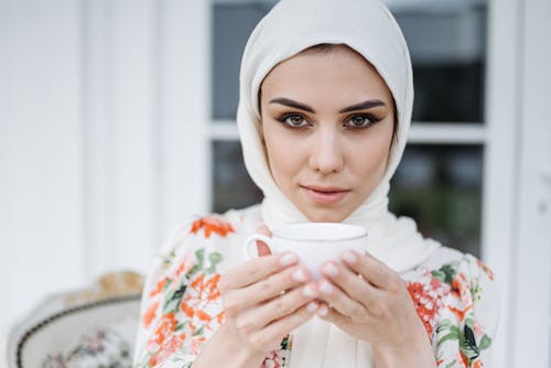 Woman in White Hijab Holding a Cup of Drink
