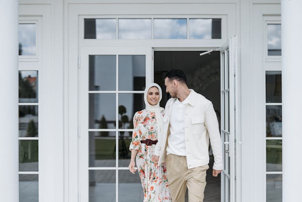 A couple in front of white French doors