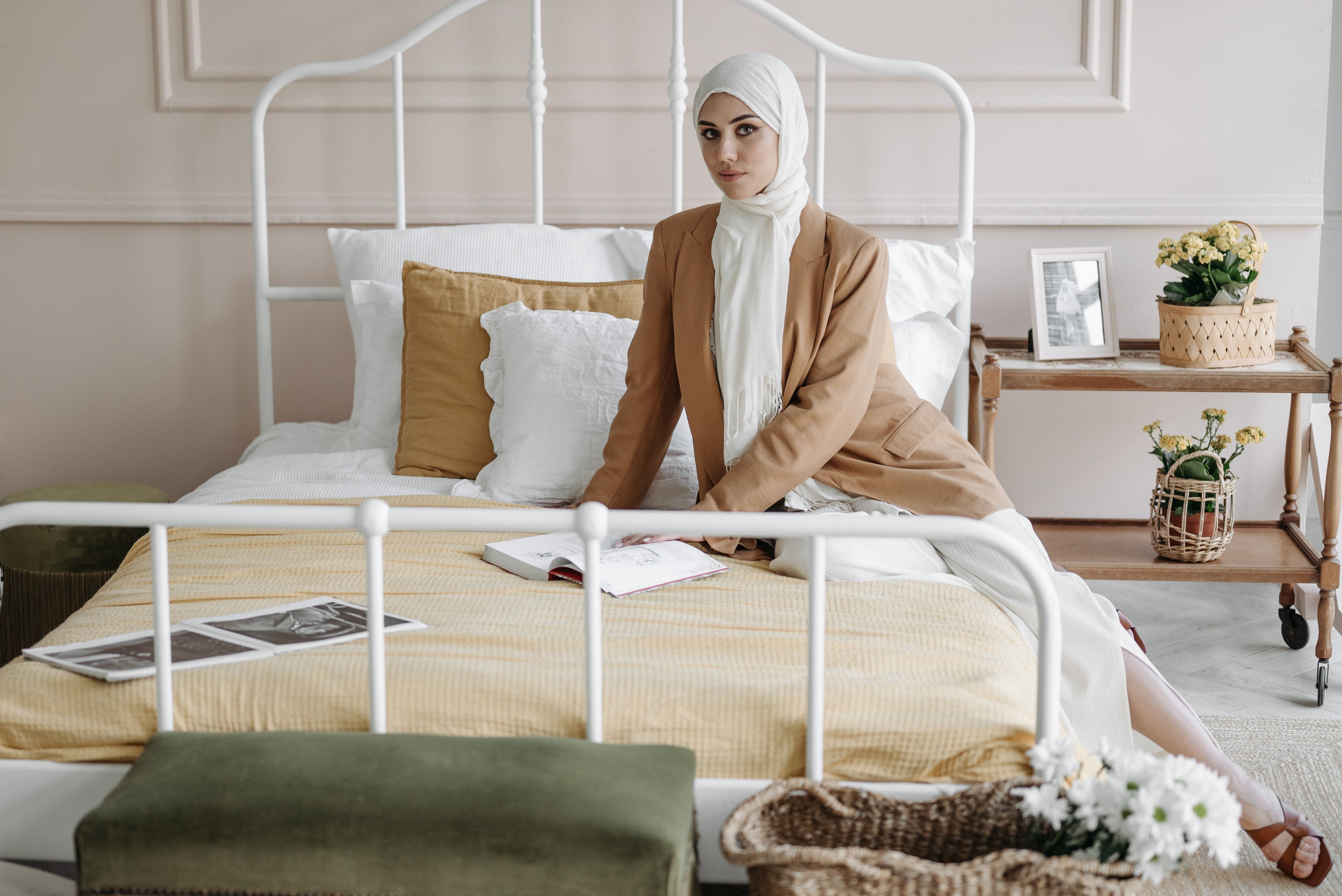 Woman in White Hijab Sitting on the Bed with a Book · Free Stock Photo