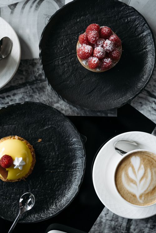 Free Overhead shot of dessert pastries and coffee on elegant black plates. Stock Photo