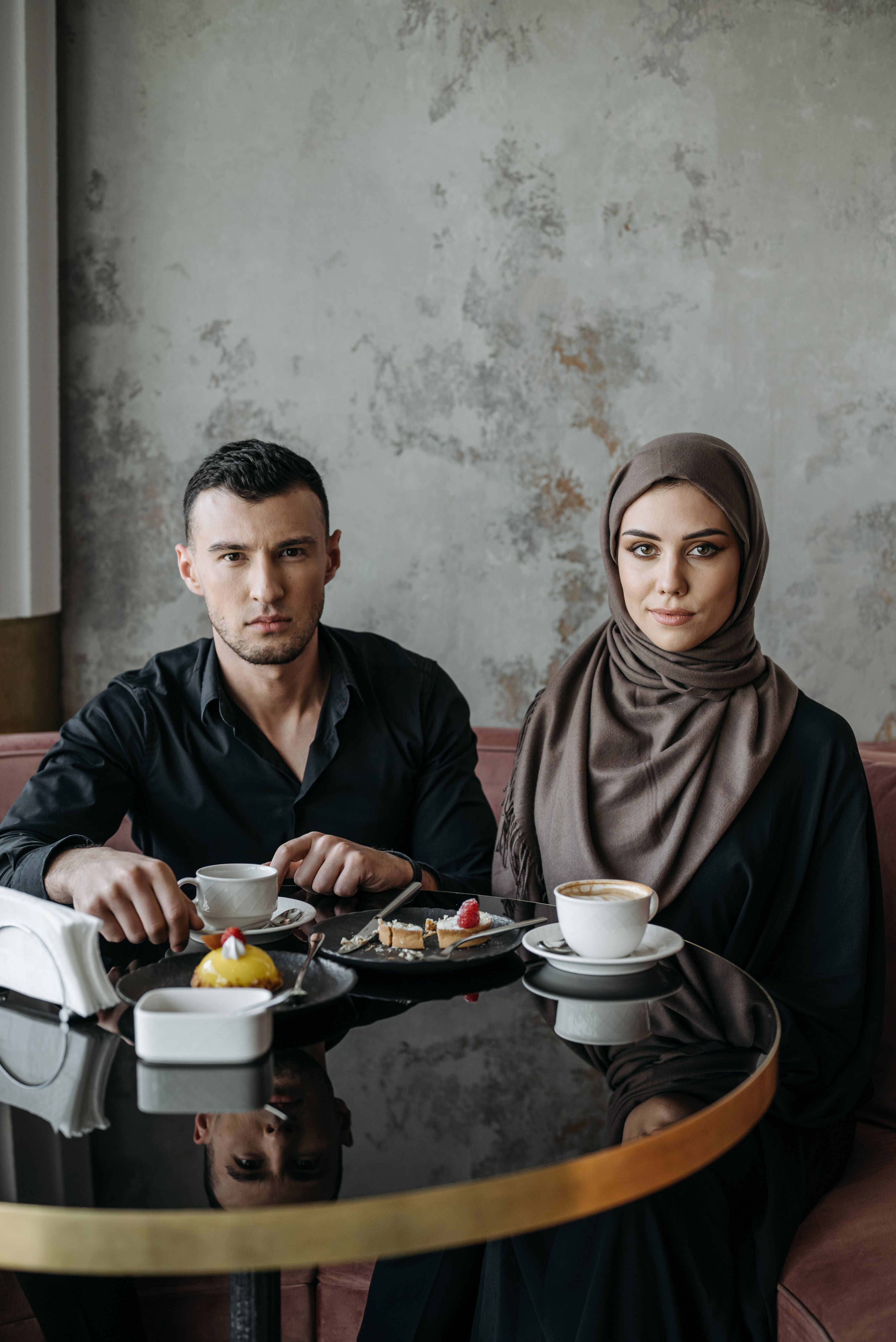 A couple sharing coffee and desserts in a cozy cafe. Relaxed atmosphere.