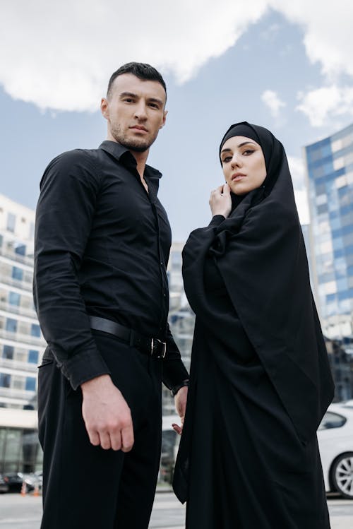 Man Standing in Front of a Woman Wearing Black Hijab