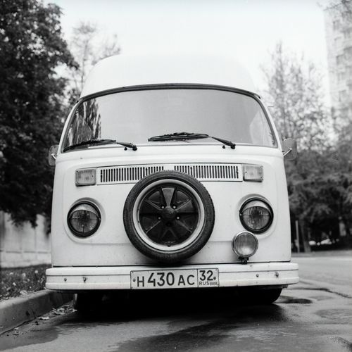Free Classic vintage van parked on an urban street captured in grayscale, highlighting retro design. Stock Photo
