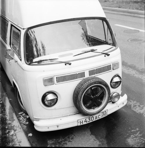 Free Classic black and white photo of a vintage camper van parked on a city street, featuring retro design elements. Stock Photo
