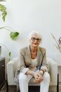 Woman in Brown Blazer Sitting on White Sofa Chair