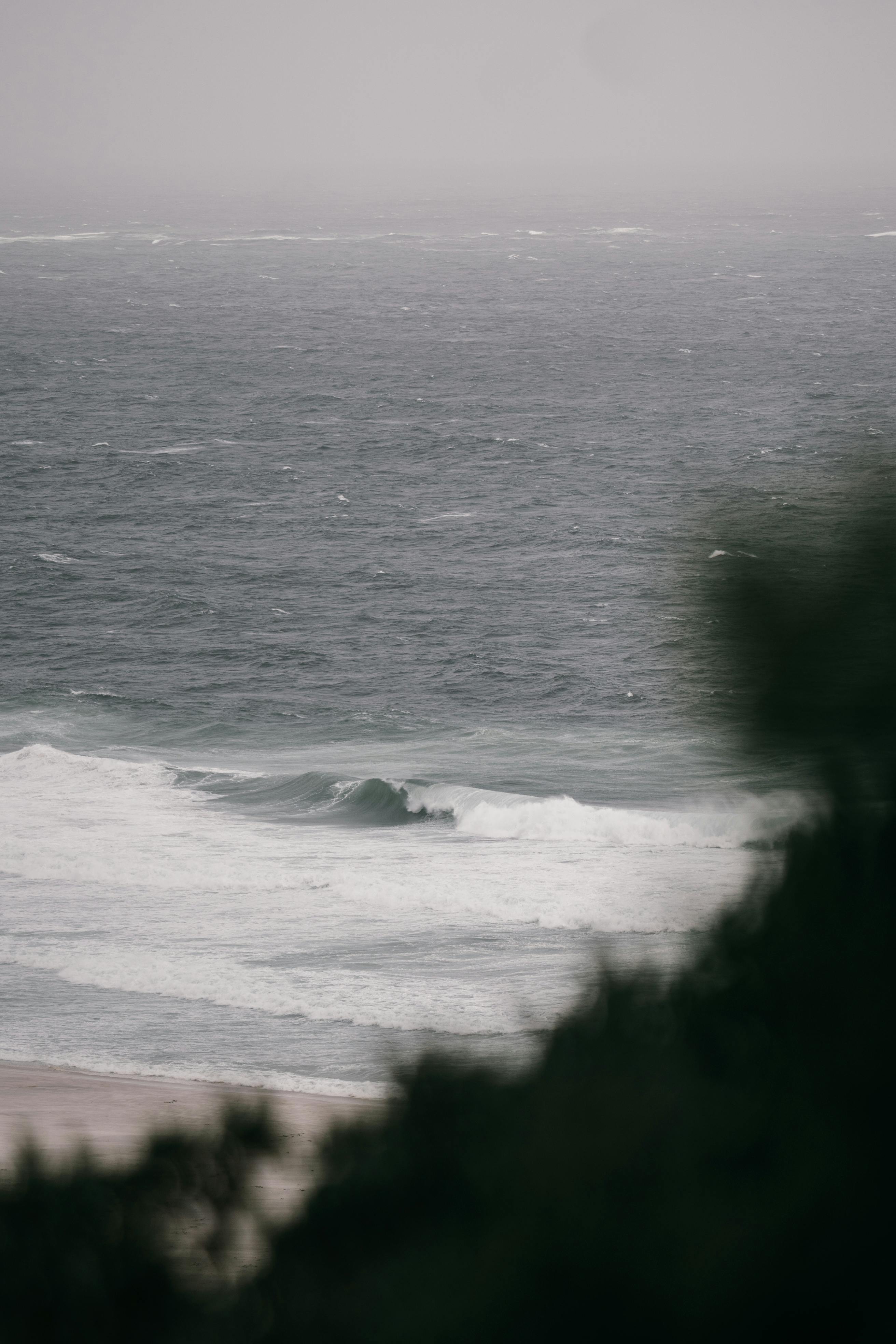 Peaceful view of crashing waves on a windy day with a serene ocean backdrop.